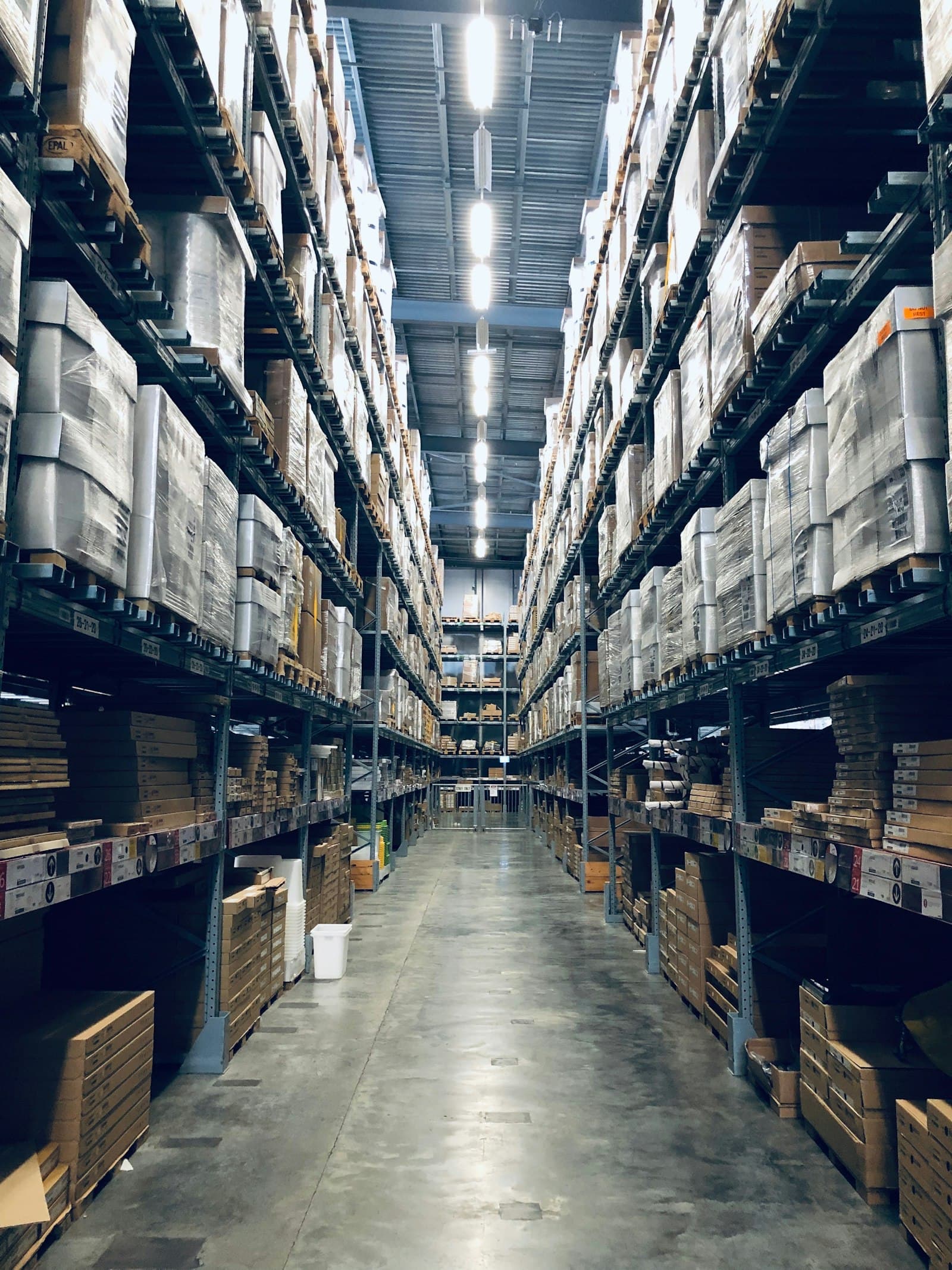 Lagerhalle mit sortierten Paletten und Containern